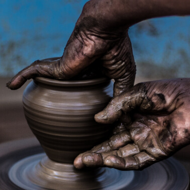 Hands forming a vessel on pottery wheel